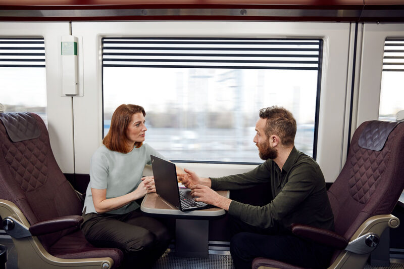 Passengers seated inside Heathrow Express train talking