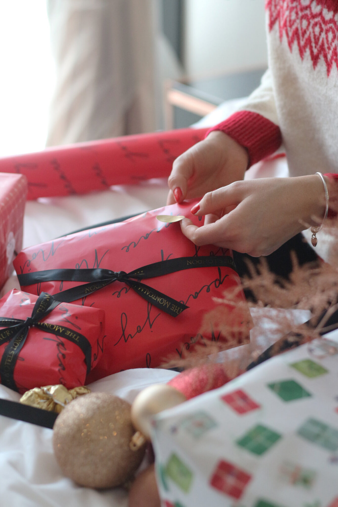 Wrapping a Christmas gift in Montcalm-branded paper and ribbon